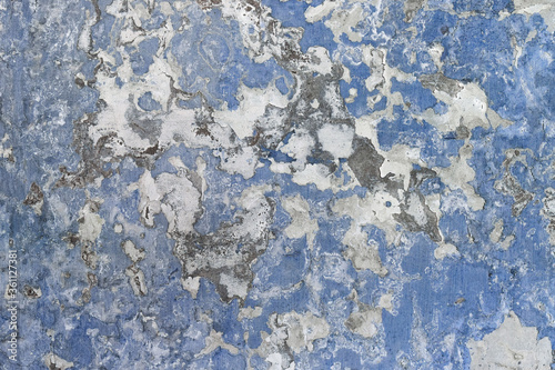 Old blue and white wall texture. Texture of the old worn wall with several layers of white and blue paint.