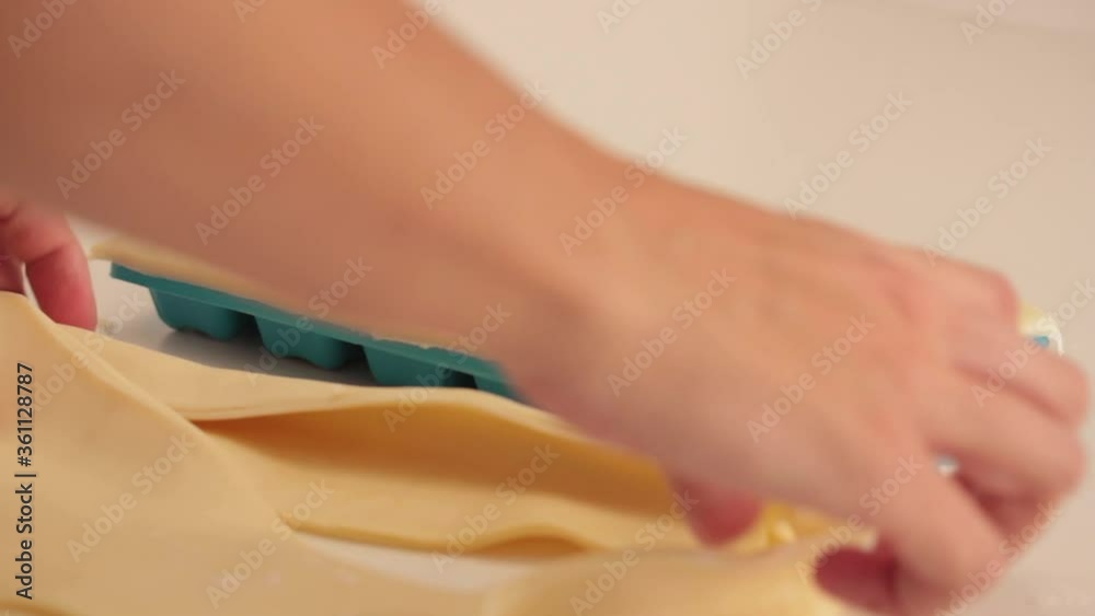 preparing ricotta cheese ravioli pasta in a plastic ice cube trays with a tart dough