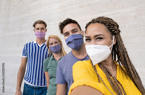 Fotografía Happy multiracial friends taking a selfie and wearing protective face masks - Co