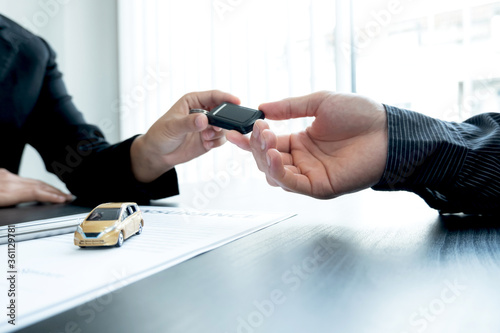 The car dealer advises the customer about insurance details and car rental information Ready delivers the keys after signing the rental contract