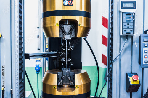 Tensile Testing, automatic tensile strength testing machine with product specimen test in the industrial factory laboratory. Mechanical properties of a material test.