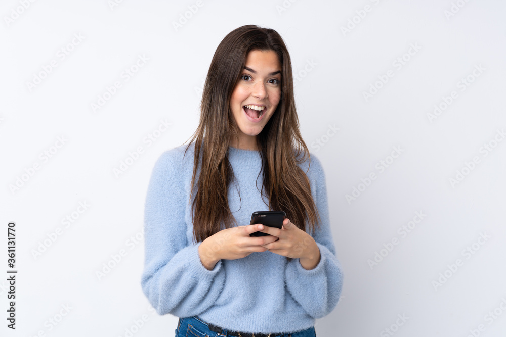 Teenager girl over isolated white background surprised and sending a message Teenager girl over isolated white background surprised and sending a message