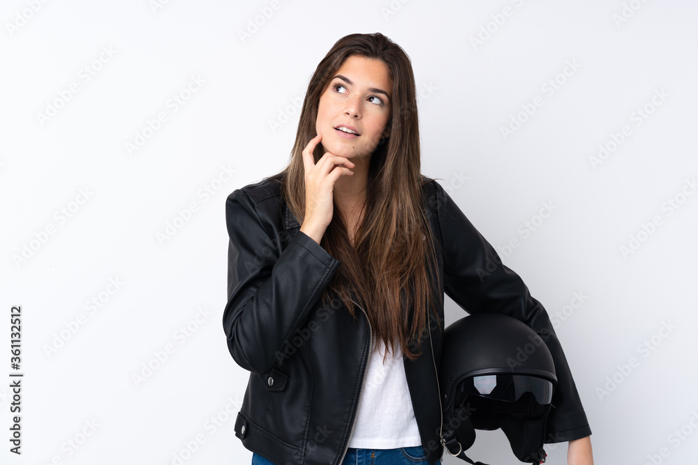 Young woman with a motorcycle helmet over isolated white background thinking an idea Young woman with a motorcycle helmet over isolated white background thinking an idea