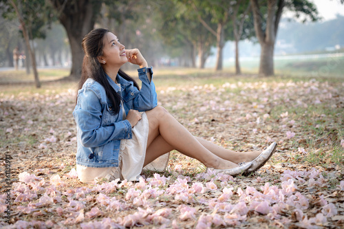 Принти на полотні Asian women sit and admire the scenery around in the morning atmosphere in the flower garden