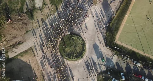 Lots of runners running in a marathon in the city of Buenos Aires, passing through a street t in the middle of the city on a sunny summer day on Vicente Lopez Argentina with the river near photo