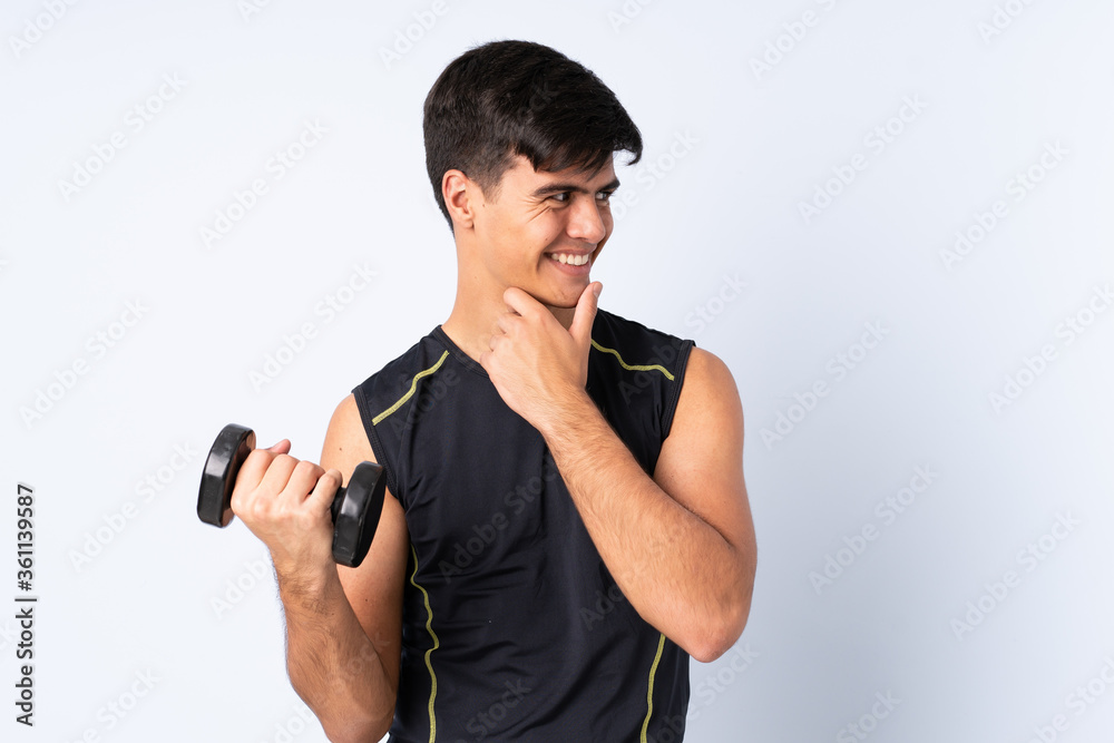 Sport man making weightlifting over isolated blue background thinking an idea and looking side