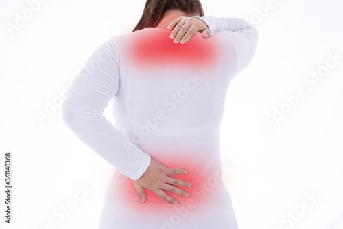A woman feeling exhausted and suffering from neck and back pain and injury on isolated white background with red spot. Health care and medical concept.