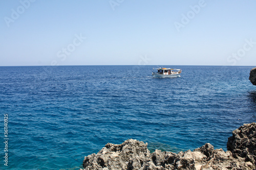 boat in the sea near the rocky shore