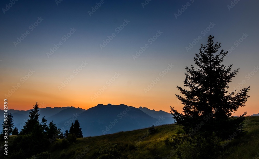 Sunset in the mountains with silhouettes of some trees