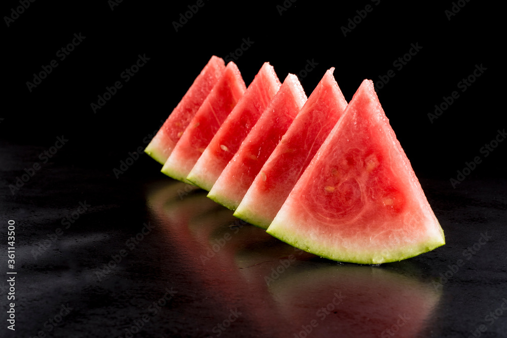 Pieces of watermelon in a black tray on a black background Pieces of watermelon in a black tray on a black background