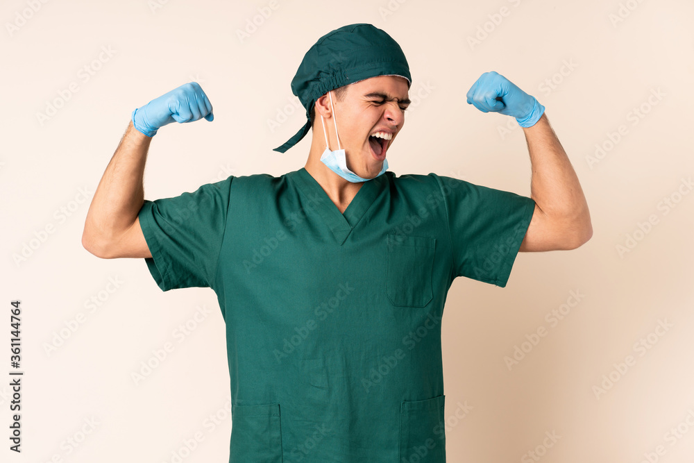 Surgeon man in blue uniform over isolated background celebrating a victory Surgeon man in blue uniform over isolated background celebrating a victory