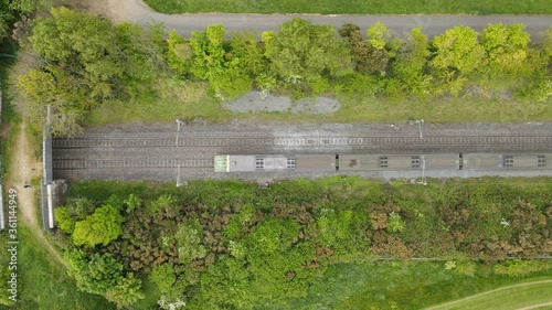 Electric train vertical following from above through green countryside photo