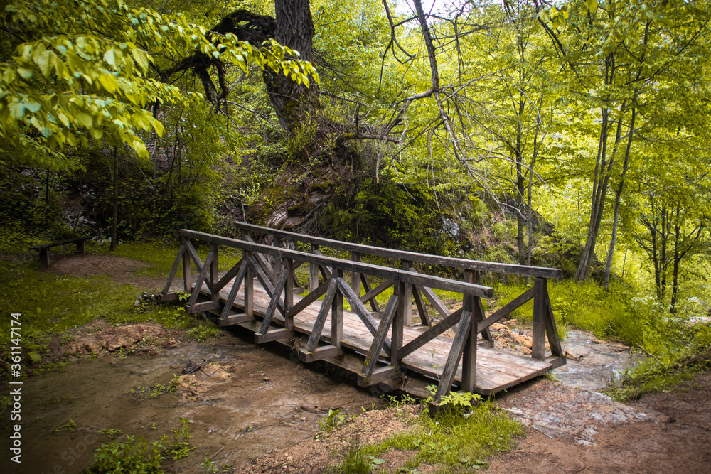 Small wooden bridge on a river near the Gostilje waterfall on Zlatibor mountain in Serbia