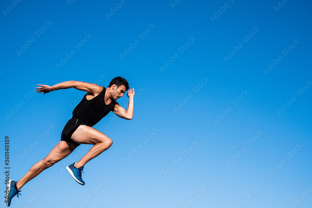 Athlete making a start in front of a blue sky Athlete making a start in front of a blue sky