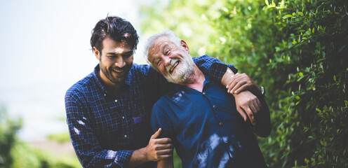 happy hipster adult son and senior father hugging at home, concept of stay at home with family