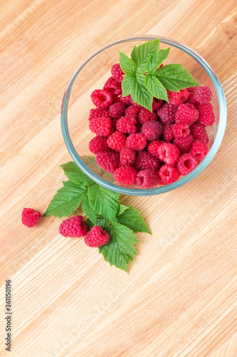 Raspberries in bowl isolated on white background