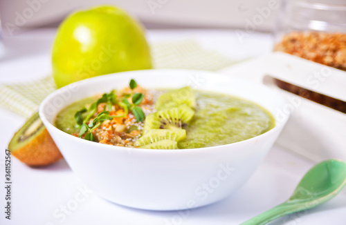 Fresh blended green smoothie bowl with muesli and chia seeds. Health and detox concept.