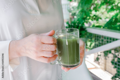 woman hands hold cup green matcha latte coffee tea glass greens leaves