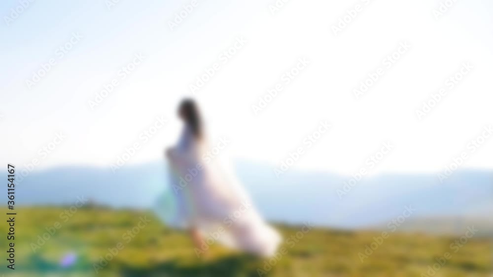 Blurred motion video. A young girl running on the mountains road. Dress fluttering in the wind. Slow motion, summer warm video. Beautiful bride in wedding dress on the sunset.
Blurred motion video. A young girl running on the mountains road. Dress fluttering in the wind. Slow motion, summer warm video. Beautiful bride in wedding dress on the sunset.