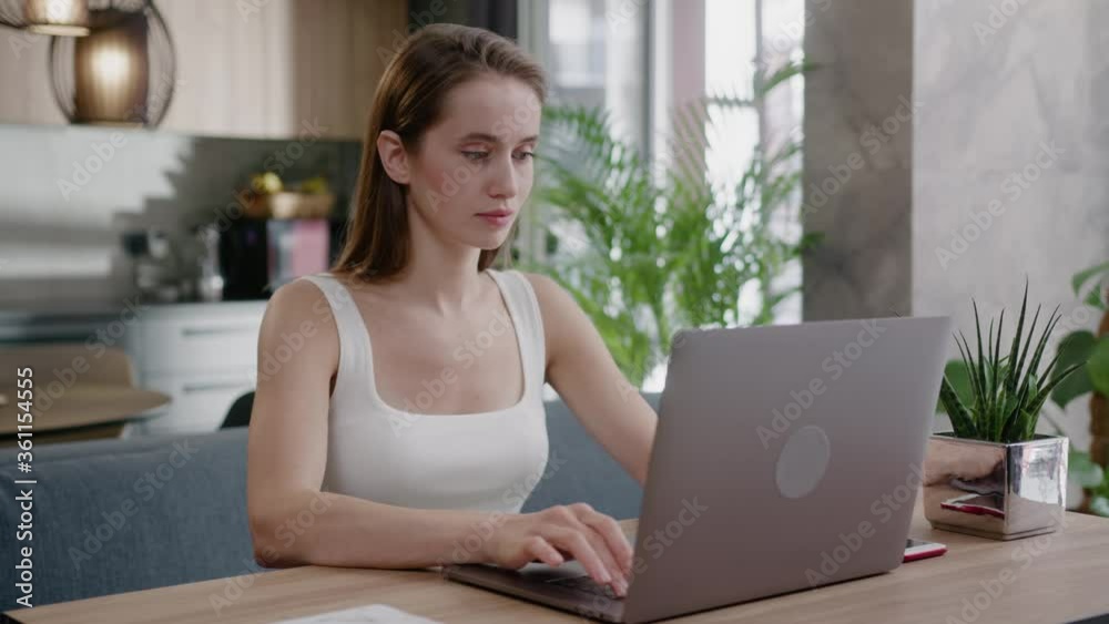 Remote businesswoman fit attractive girl working on portable laptop, performing job assignments, staying at home. Social distance. Freelance. Interiors. Remote businesswoman fit attractive girl working on portable laptop, performing job assignments, staying at home. Social distance. Freelance. Interiors.
