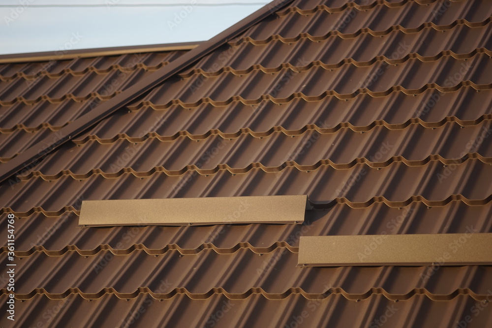 Close-up of brown tiled roof in sunny day.