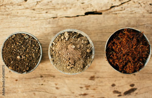 Top view of material for planting seeds (soil, organic manure, coconut coir husk fiber) in plastic pots.