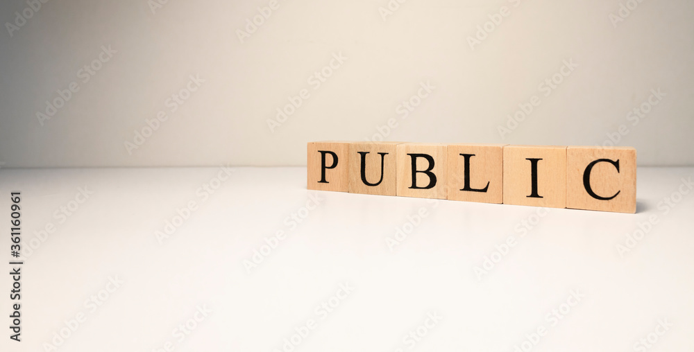 Public text from wooden cubes. Close-up photographed in studio. In spot light Public text from wooden cubes. Close-up photographed in studio. In spot light