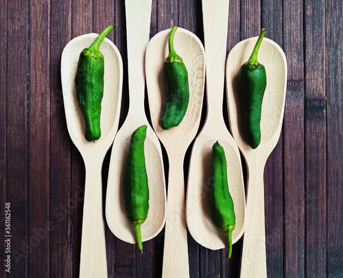 Padrón peppers background on spoon and wooden table