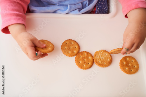 children's hands hold cookie crackers. Close-up. Top view.