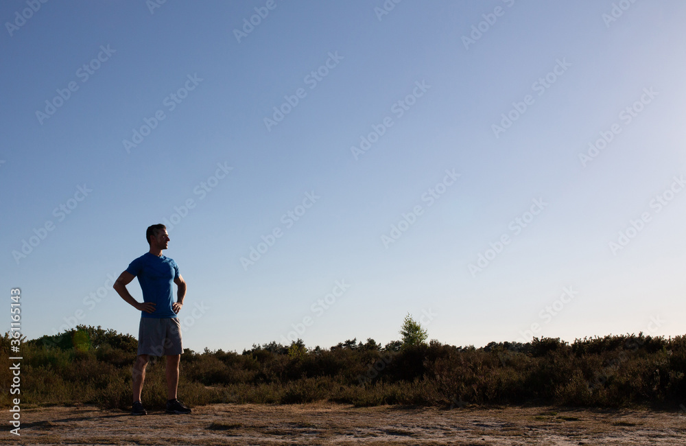 Man standing after fitness looking at view Man standing after fitness looking at view