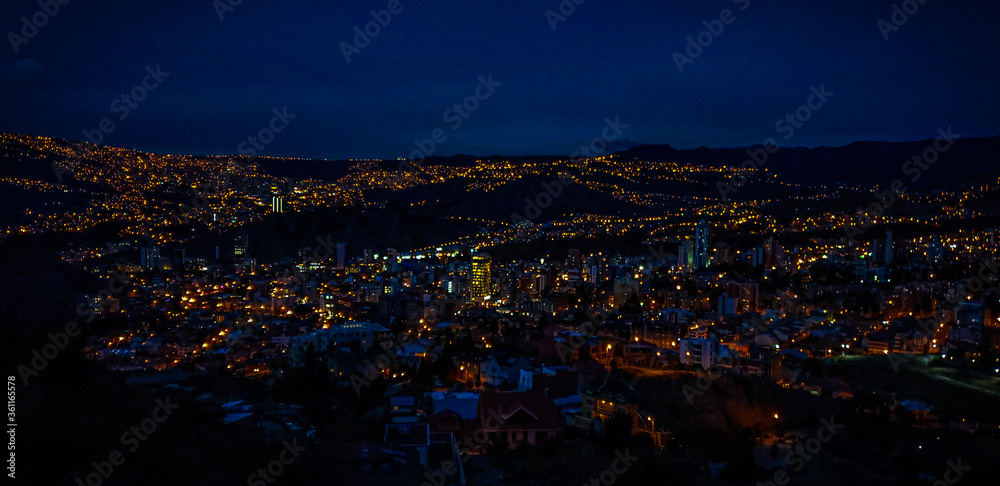 Night city with lights and between mountains
