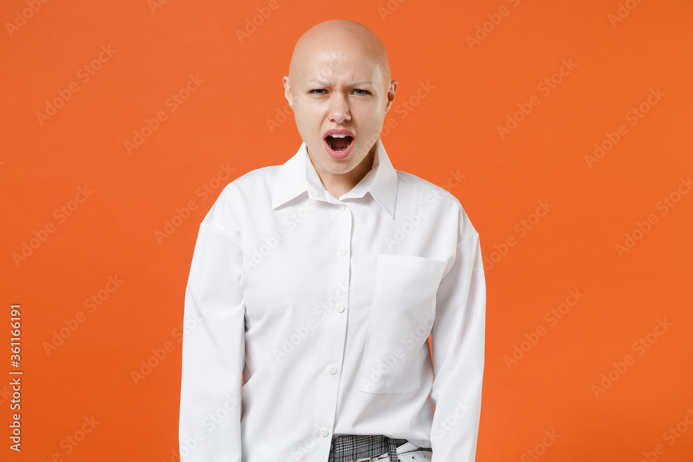 Shocked worried young bald business woman girl in white shirt posing isolated on orange background studio portrait. Achievement career wealth business concept. Mock up copy space. Keeping mouth open. Shocked worried young bald business woman girl in white shirt posing isolated on orange background studio portrait. Achievement career wealth business concept. Mock up copy space. Keeping mouth open.