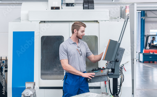 Worker operating computer-controlled machine tool