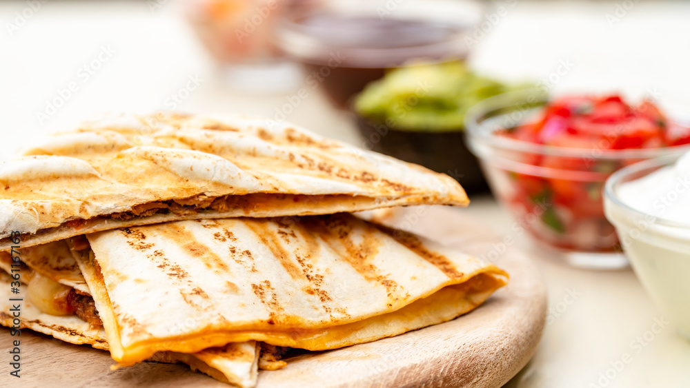 Mexican traditional authentic homemade quesadilla with pulled pork beef chili con carne serve with tomato salad and avocado guacamole and dip sauce Mexican traditional authentic homemade quesadilla with pulled pork beef chili con carne serve with tomato salad and avocado guacamole and dip sauce