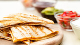 Mexican traditional authentic homemade quesadilla with pulled pork beef chili con carne serve with tomato salad and avocado guacamole and dip sauce