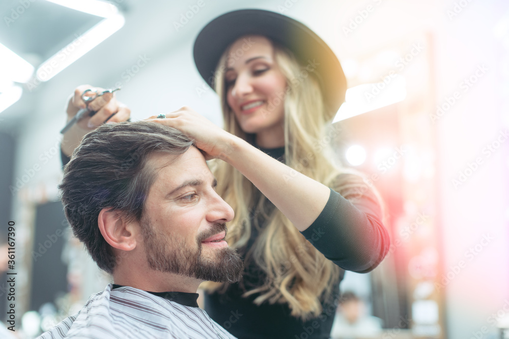 Fototapeta premium Hair stylist trying to get her client a proper cut