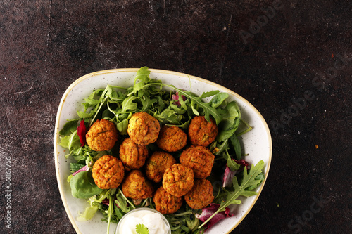 roasted falafel chickpeas patties with garlic yogurt sauce on table