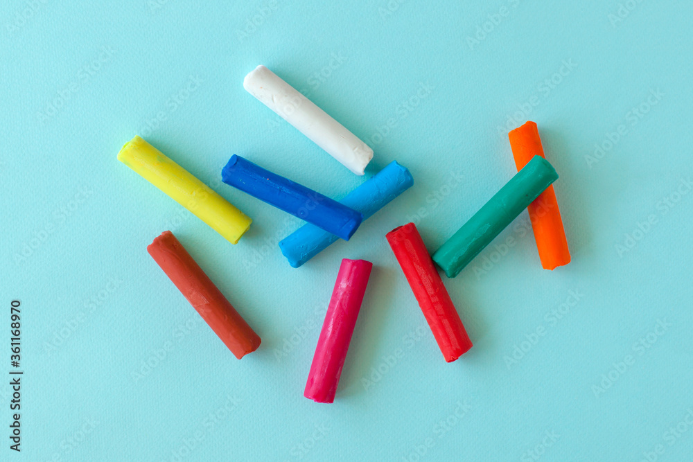 Multi-colored children's plasticine on a blue background. Craft with kids. Art tools. Multi-colored children's plasticine on a blue background. Craft with kids. Art tools.