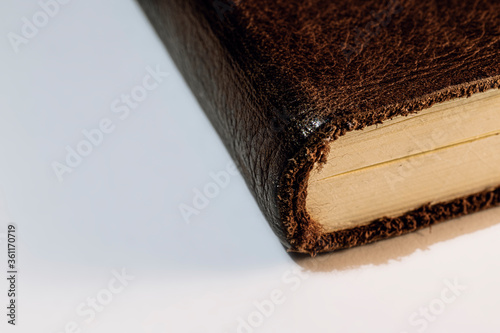 Corner of a leather bound book on a white background