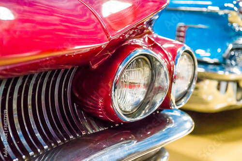 Headlight of red retro car and blue retro car on background