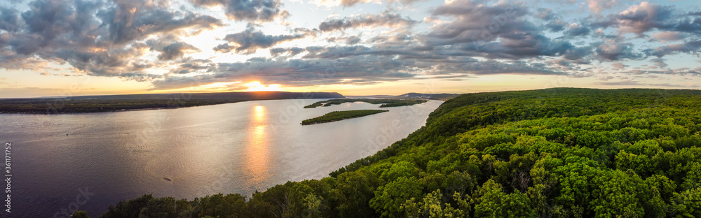 Aerial panoramic landscape view on Volga river with small sand islands and green forest on hills during summer sunset, Samara, Russia