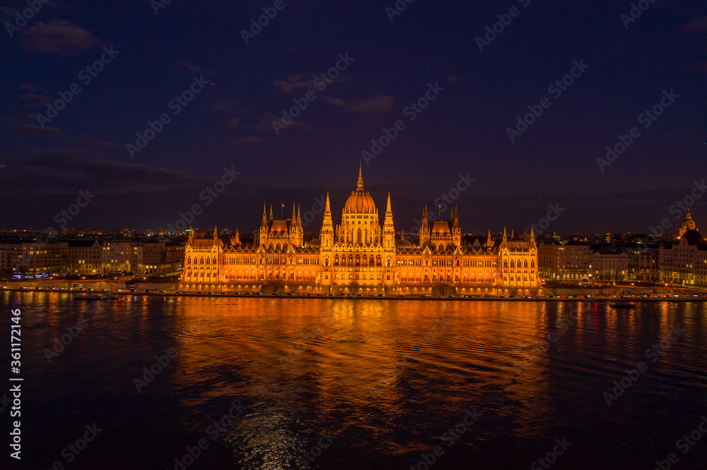 Aerial drone shot of Hungarian Parliament with lights on during Budapest evening