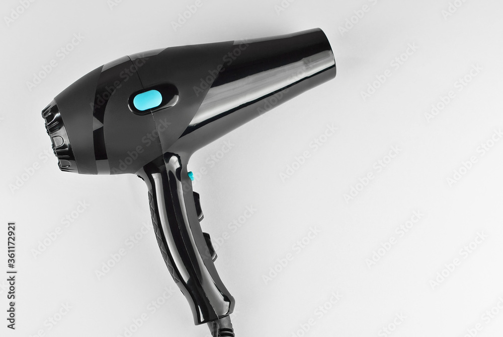 Black hair dryer isolated on a white background. Hairdresser tool close up.