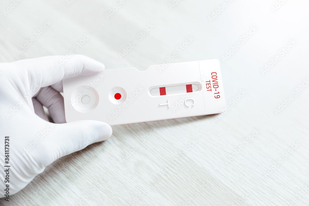Hand holding fast test result against Covid-19. Positive result. Hand holding fast test result against Covid-19. Positive result.