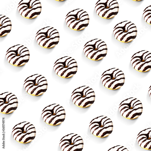 Glazed striped donuts on white background. Party food concept with copy space. Top view.