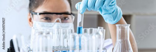 Scientist in lab working in laboratory using equipment for research