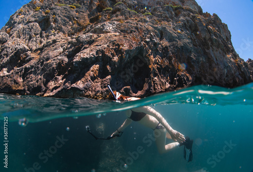 Beautiful girl swimming and freediving in the blue crystal clear mediterranean sea photo