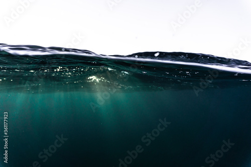 Rays of light shining through the surface of the atlantic ocean, into the deep, blue and dark abyss