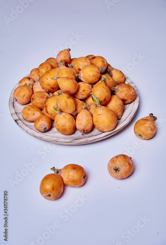 Medlars in a wooden plate and on the table