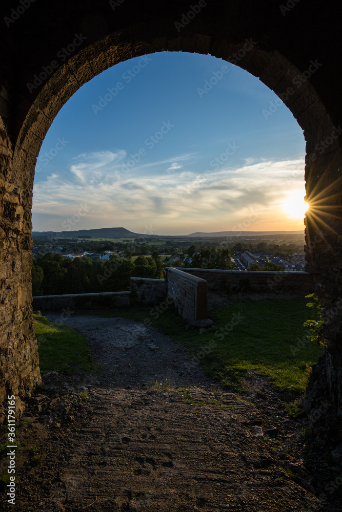 Viewpoint from Clitheroe castle looking through an arch into the Ribble valley. Sunset over Longridge fell